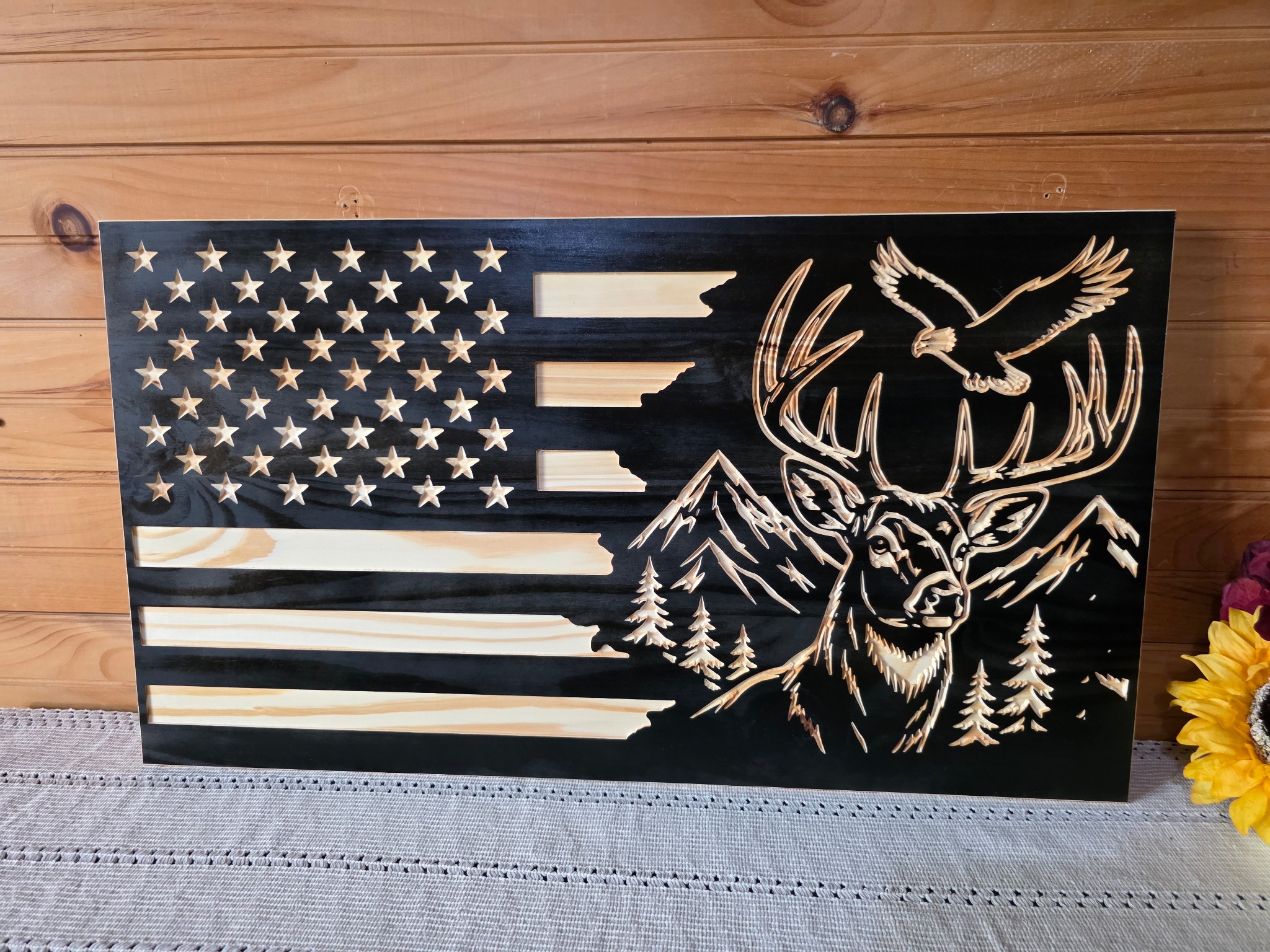 Carved wood American flag with a whitetail buck, mountains, trees, and an eagle